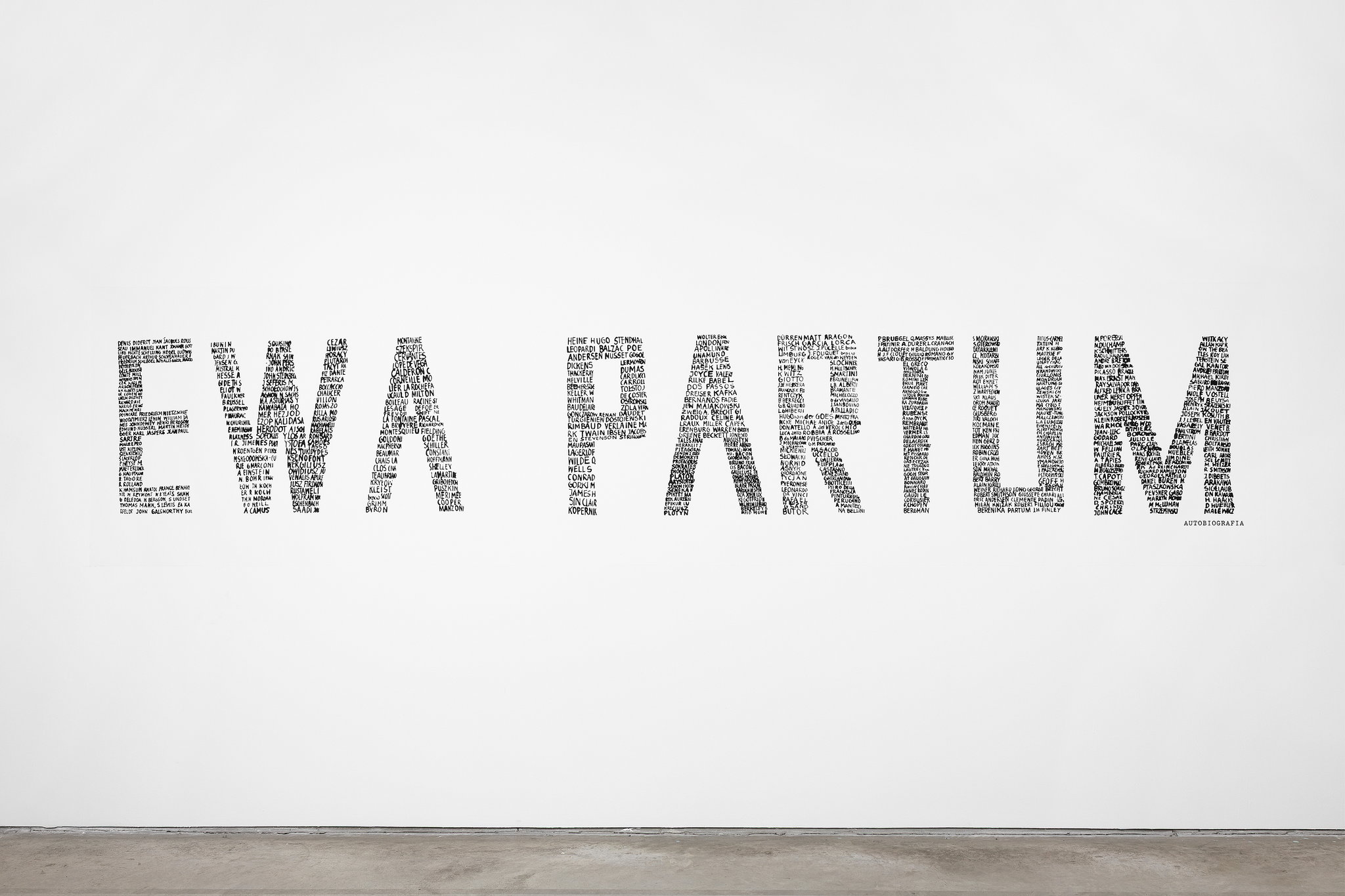 Praca z napisem EWA PARTUM na białej ścianie wystawy w MOCAK-u