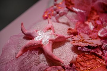 Różowy obiekt w kształcie rozgwiazdy ze srebrzystym środkiem na wystawie Zabaweczki Kamili Jajkowskiej